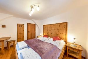 a bedroom with a large bed with a wooden headboard at Florerhof Ferienwohnung Rose in Vols am Schlern