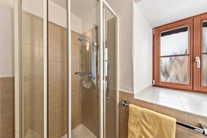a glass shower in a bathroom with a window at Florerhof Ferienwohnung Rose in Vols am Schlern
