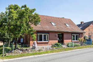 a brick house with a fence in front of it at Kleines Glück in Seedorf