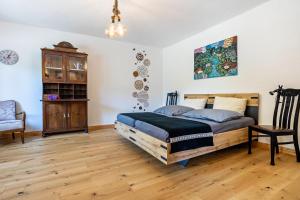 a bedroom with a wooden bed and a chair at Kleines Glück in Seedorf