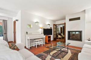 a living room with a fireplace and a white piano at Villa Elisabeth in Fréjus