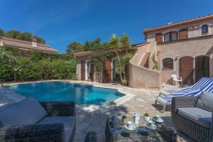a villa with a swimming pool in front of a house at Villa Elisabeth in Fréjus