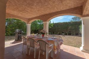a table and chairs on a patio with a grill at Villa Elisabeth in Fréjus