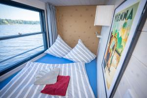 a room with two pillows and a window on a boat at Exklusives Naturerlebnis Roxy in Fürstenberg