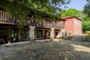 a house with a balcony on top of it at Quinta de Amares in Amares