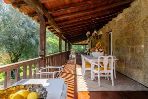 a wooden deck with a table and chairs on it at Quinta de Amares in Amares