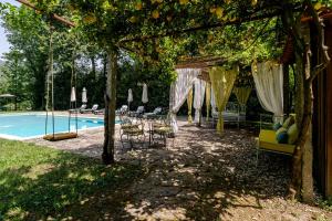 a pool with chairs and a pergola with a table and chairs at Quinta de Amares in Amares