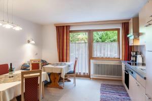 a kitchen and dining room with a table and a window at Ferienwohnung Dornauer Sommer in Hippach