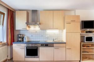 a kitchen with white cabinets and blue counter tops at Ferienwohnung Dornauer Sommer in Hippach +27 photos