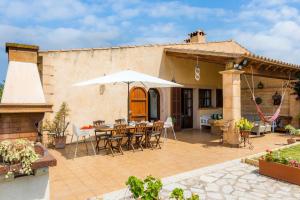 a patio with a table and chairs and an umbrella at Finca Kelly in Artá