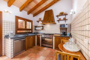 a kitchen with wooden cabinets and a table in it at Finca Kelly in Artá