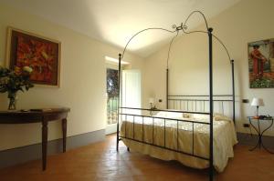 a bedroom with a canopy bed and a table at Villa Arnilù in San Gimignano
