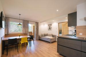 a kitchen and living room with a table and yellow chairs at Balbeinhof Apt Hirsch in Luson