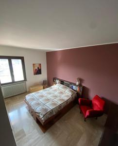 a bedroom with a bed and a red chair at Dall'alba al Tramonto in Alezio