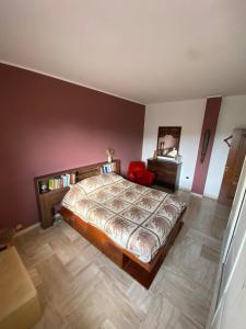 a bedroom with a large bed and a red chair at Dall'alba al Tramonto in Alezio +9 photos
