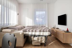 a bedroom with a bed and a tv in it at Mountain Meadows Apt 2 in Valdaora