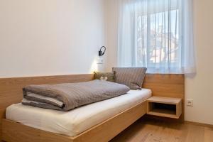 a bed sitting in a room with a window at Mountain Meadows Apt 2 in Valdaora