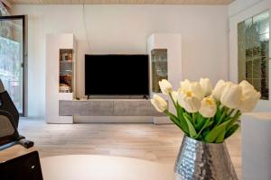a living room with a tv and a vase of flowers at Fewo Talblick mit Schwimmbad in Bad Wildbad