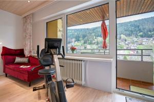 a living room with a red couch and a large window at Fewo Talblick mit Schwimmbad in Bad Wildbad
