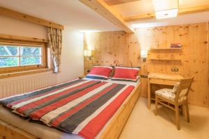 a bedroom with a bed with a desk and a window at Chalet Zur Auszeit in Aschau +37 photos
