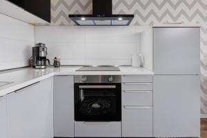 a kitchen with white cabinets and a stove top oven at Ferienwohnung Sally in Lenzkirch