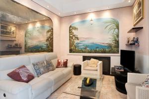 a living room with a white couch and a painting at Capriccio in Bordighera