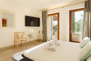a bedroom with a large bed with a television on the wall at Finca Playa Llenaire - Can Pou in El Port +37 photos