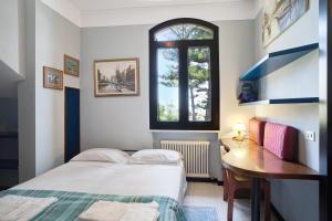 a bedroom with a bed and a desk and a window at Capriccio in Bordighera
