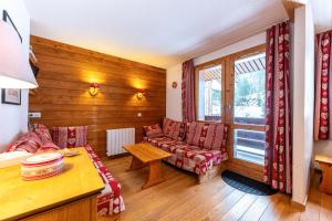 a living room with a couch and a table at Lauziere dessus 50 in Valmorel