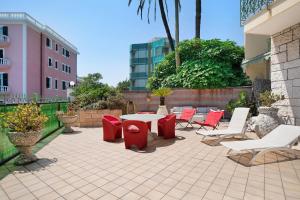 a patio with red and white chairs and a table at Capriccio in Bordighera