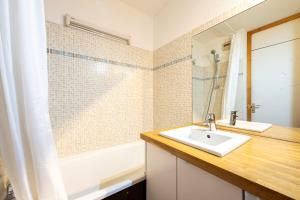 a bathroom with a sink and a bath tub at Lauziere dessus 50 in Valmorel +15 photos