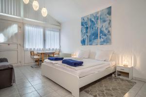 a white bedroom with a bed and a table at Fewo Eg Links - Hunde erlaubt in Oberteuringen
