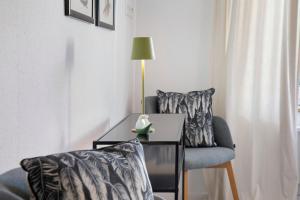 a living room with a chair and a table and a lamp at Waldmariechen in Neresheim +22 photos