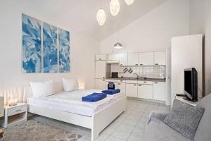 a white bedroom with a large bed and a kitchen at Fewo Eg Links - Hunde erlaubt in Oberteuringen