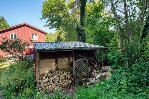 a shed full of fire wood in front of a red barn at Ferien Tinyhaus im Tale in Ascheffel