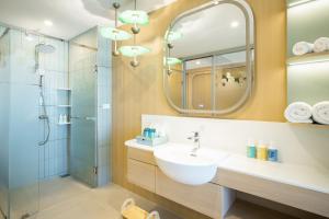 a bathroom with a sink and a shower with a mirror at Katathani Phuket Beach Resort - SHA Extra Plus in Kata Beach