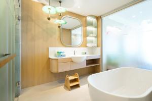 a bathroom with a tub and a sink and a mirror at Katathani Phuket Beach Resort - SHA Extra Plus in Kata Beach