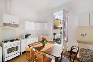 a kitchen with a wooden table and a kitchen with white cabinets at Dai Baccino in Celle Ligure