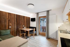 a kitchen and living room with a table and chairs at Pfaffingerhof Antholz in Masserie
