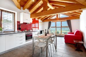 a kitchen with a table and a red couch at La Maison De Carletto in Sarre