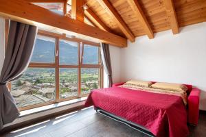 a bedroom with a red bed and a large window at La Maison De Carletto in Sarre