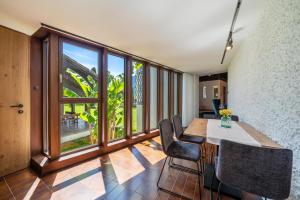 a dining room with a table and chairs and a large window at Thanhammer Apt Quarz in Terlano