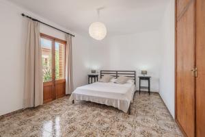 ein weißes Schlafzimmer mit einem Bett und einem Fenster in der Unterkunft C'an Crespí in Consell + 17 Fotos