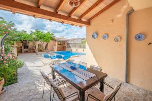 eine Terrasse mit Tisch und Stühlen und ein Pool in der Unterkunft C'an Crespí in Consell