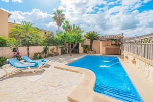 ein Swimmingpool in einem Garten mit einem blauen Stuhl und einer Terrasse in der Unterkunft C'an Crespí in Consell