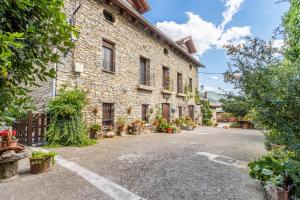 a stone building with potted plants on a street at Casa Perico in Borrastre