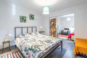 a bedroom with a bed with a floral bedspread at Casa de Campo Serrão in Calheta