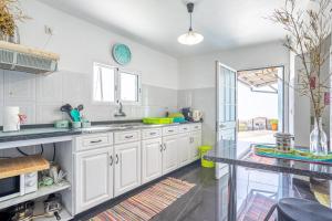 a kitchen with white cabinets and a counter top at Casa de Campo Serrão in Calheta