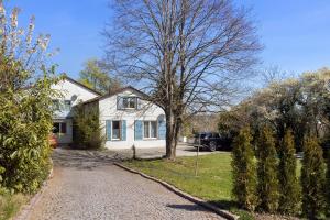 a white house with a tree and a driveway at Hegaudomizil in Engen
