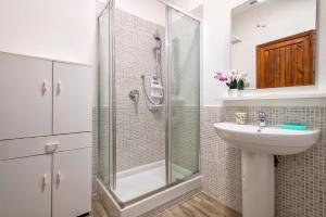 a bathroom with a glass shower and a sink at Casa al mare con ampia veranda in Stintino